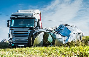 Links steht ein Lkw, rechts daneben liegt ein Auto, das verbeult ist.