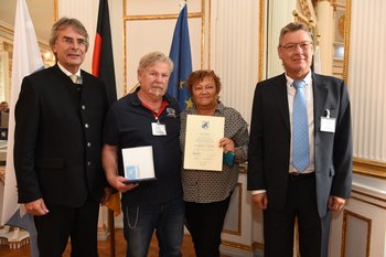 Kurt und Brunhild Blasi, Foto: Tino Lex Drei Männer und eine Frau stehen nebeneinander. Die Frau hält eine Urkunde