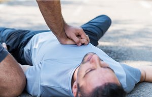 Ein Mann übt an einem anderen Mann die Herzdruckmassage aus.