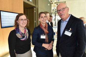 Zwei Frauen und ein Mann stehen nebeneinander