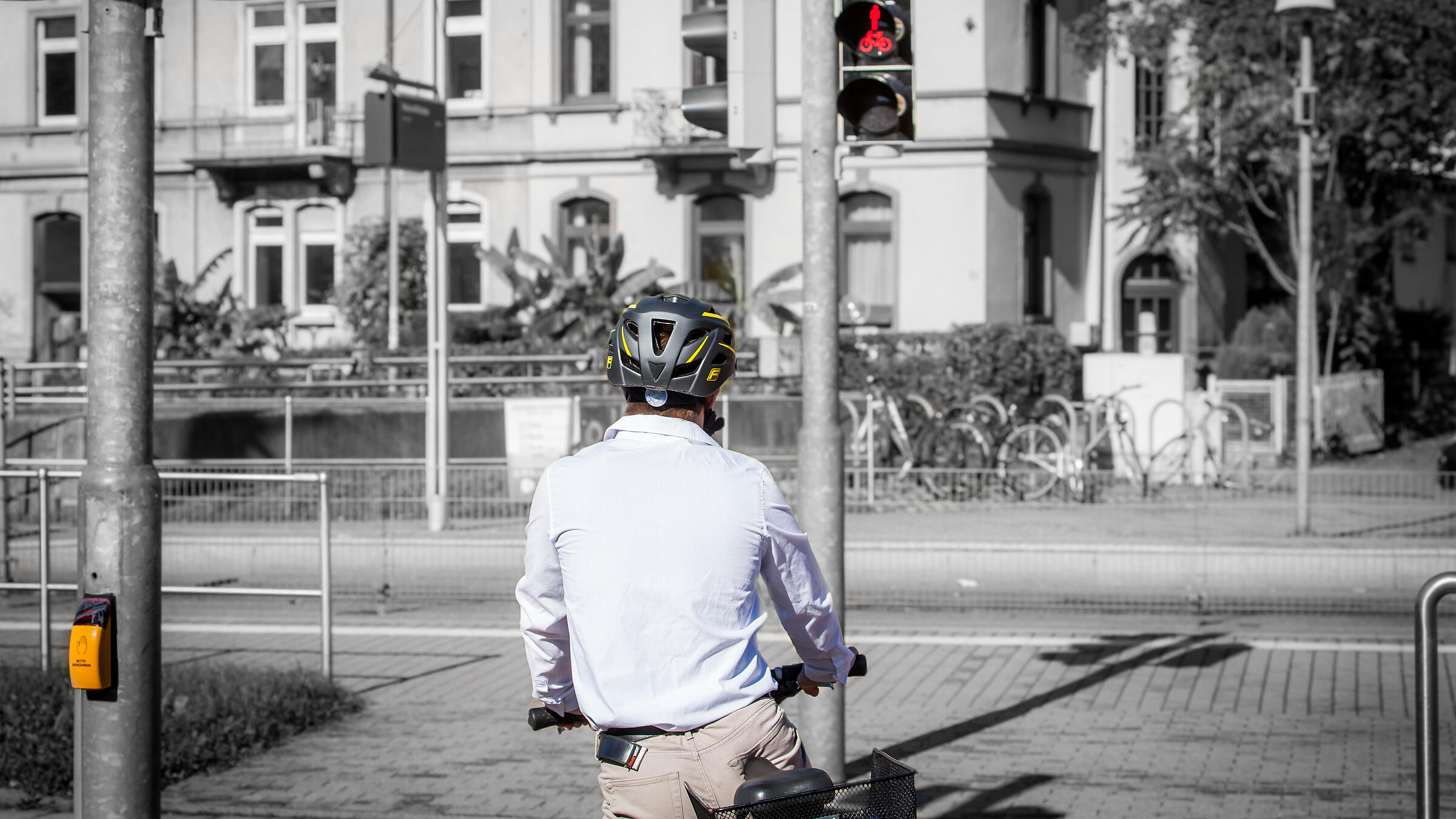 Ein Fahrradfahrer wartet an einer roten Ampel.