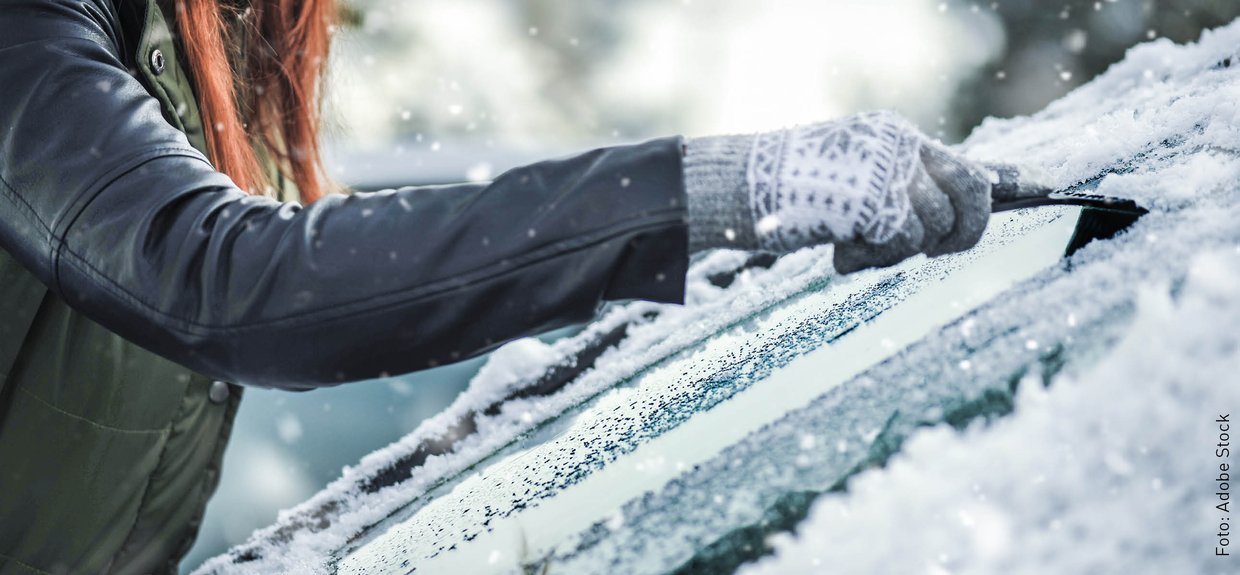 Autoscheibe frei kratzen Jemand befreit eine Scheibe von Schnee
