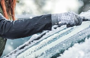 Jemand befreit eine Scheibe von Schnee