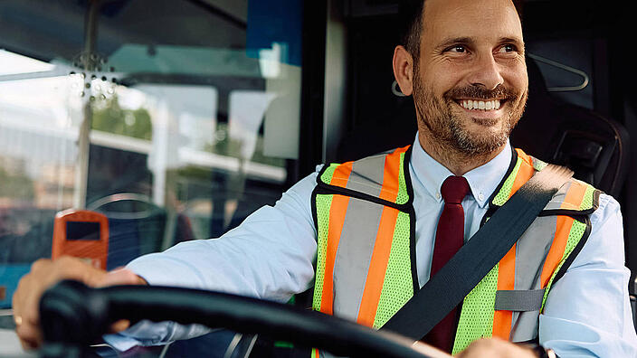 Happy bus driver driving  bus.
