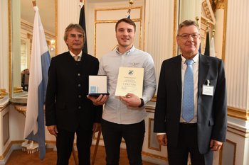 Brendon Westervelt, Foto: Tino Lex Drei Männer stehen nebeneinander. Der mittlere hält eine Urkunde