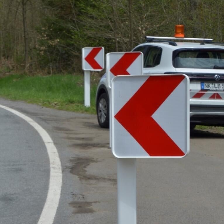 Ein Auto parkt hinter Leittafeln auf dem Seitenstreifen.