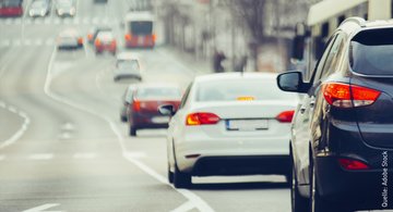 Mehrere Autos fahren auf einer dreispurigen Fahrbahn.
