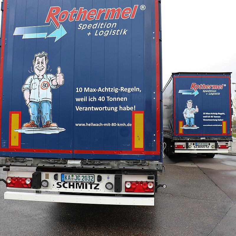 Auf dem Bild ist die Rückseite eines LKWs zu sehen, auf dem ein Bild von Max Achtzig zu sehen ist. Auf dem LKW steht: 10 Max-Achtzig-Regeln, weil ich 40 Tonnen Verantwortung habe!