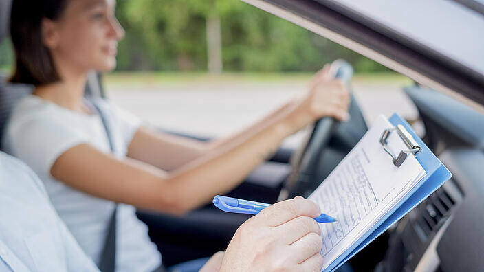 Zwei junge Frauen lachend im Auto.