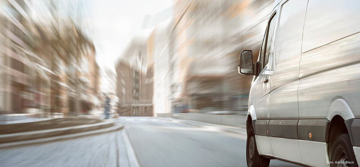 Der DVR bietet ein Fahrsicherheitsprogramm Transporter zur Weiterbildung an. Foto: Adobe Stock Ein weißer Transporter fährt durch eine Stadt.