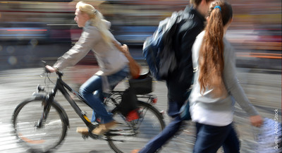 Eine Radfahrerin fährt auf dem Gehweg. Eine Radfahrerin fährt auf dem Gehweg.