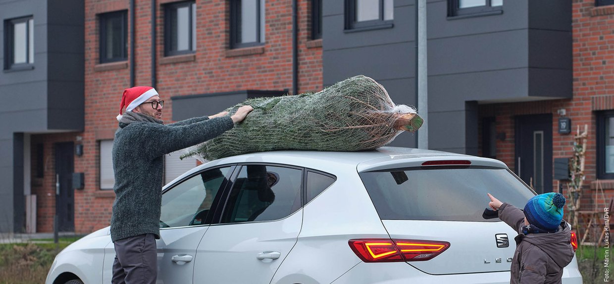Ein Tannenbaum liegt auf dem Dach eines Autos Ein Tannenbaum liegt auf dem Dach eines Autos