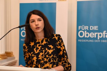 Andrea Jakob, stellvertretende Chefredakteurin der Mittelbayerischen Zeitung. Foto: Tino Lex Eine Frau steht hinter einem Pult mit Mikrofon
