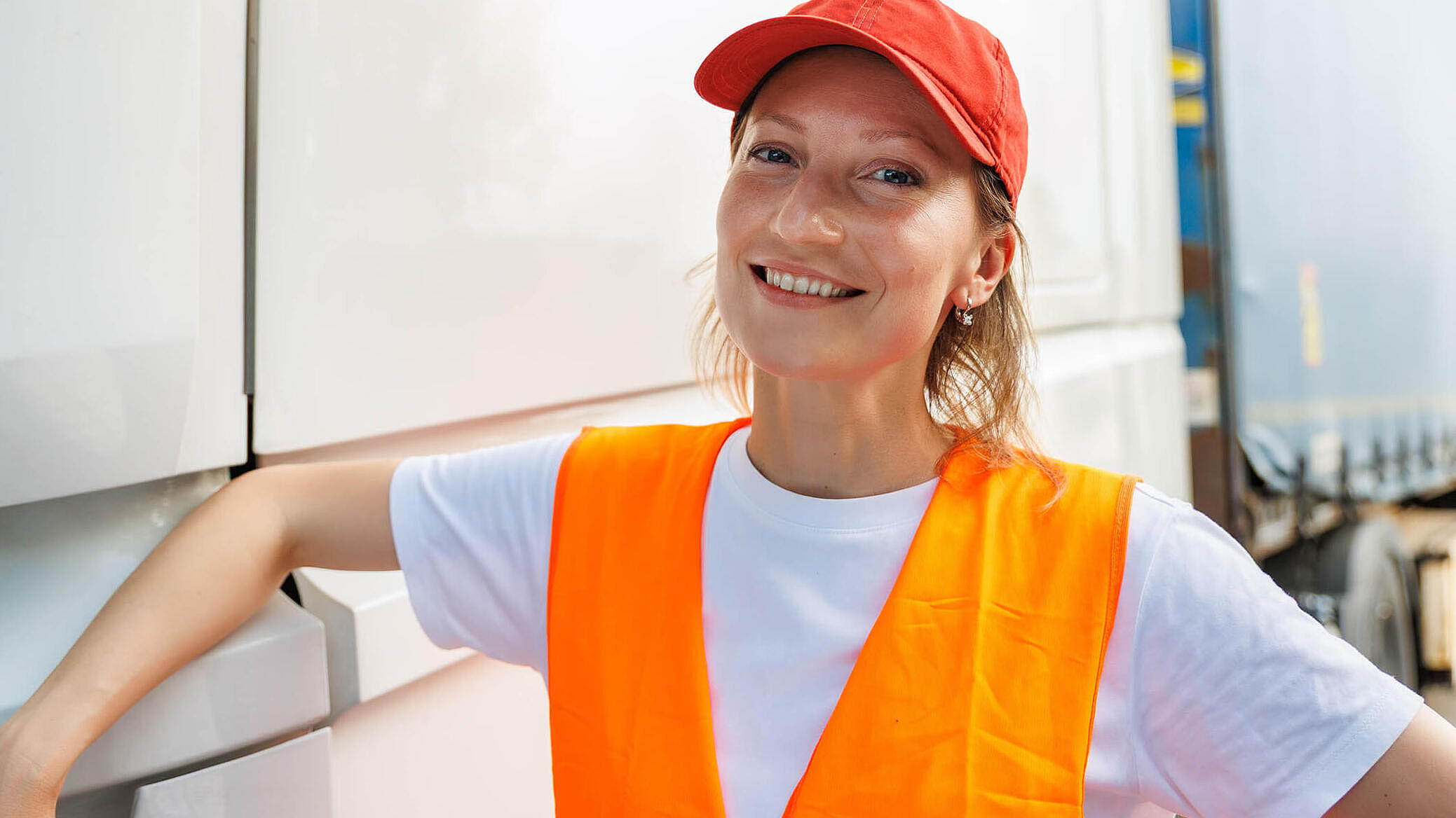 Portrait young adult happy smiling woman heavy truck driver modern cargo vehicle cabin background. Female person girl professional job career working driving freight engine lorry. Logistics industry