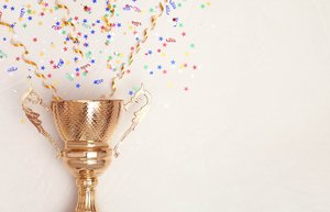 Aus einem goldenen Pokal kommt Konfetti