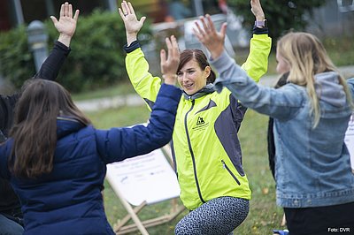 Drei Frauen strecken die Hände in die Höhe.