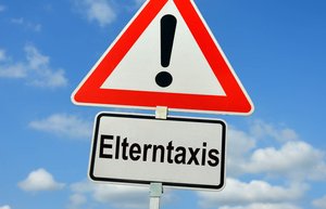 Verkehrszeichen Achtung, darunter Zusatzzeichen Elterntaxi