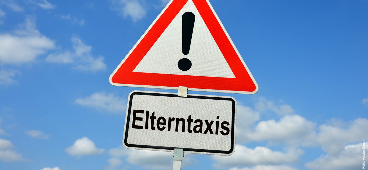 Achtung Elterntaxi! Verkehrszeichen Achtung, darunter Zusatzzeichen Elterntaxi