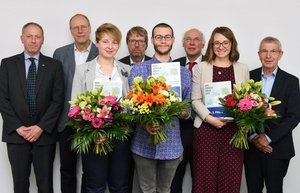 Die DVR-Förderpreisgewinner 2019 mit Blumensträußen und Urkunden in den Händen, welche gemeinsam mit den Juroren vor weißer Wand stehen.