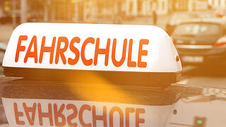 Ein Auto mit einer Dachannbringung auf der Fahrschule steht