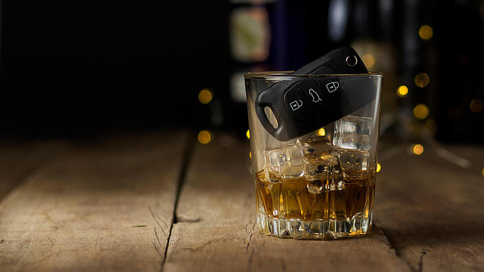 Autoschlüssel in einem Glas mit einem alkoholischen Getränk
