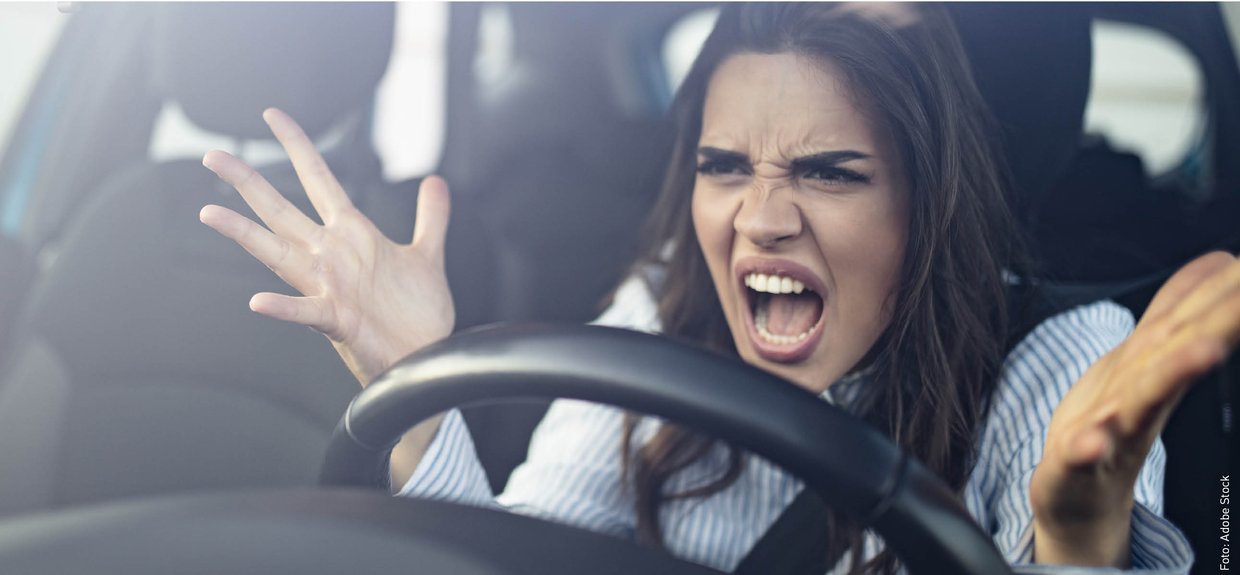 Aggressionen im Straßenverkehr. Foto: Adobe Stock Eine Frau schaut böse hinterm Lenkrad und gestikuliert.