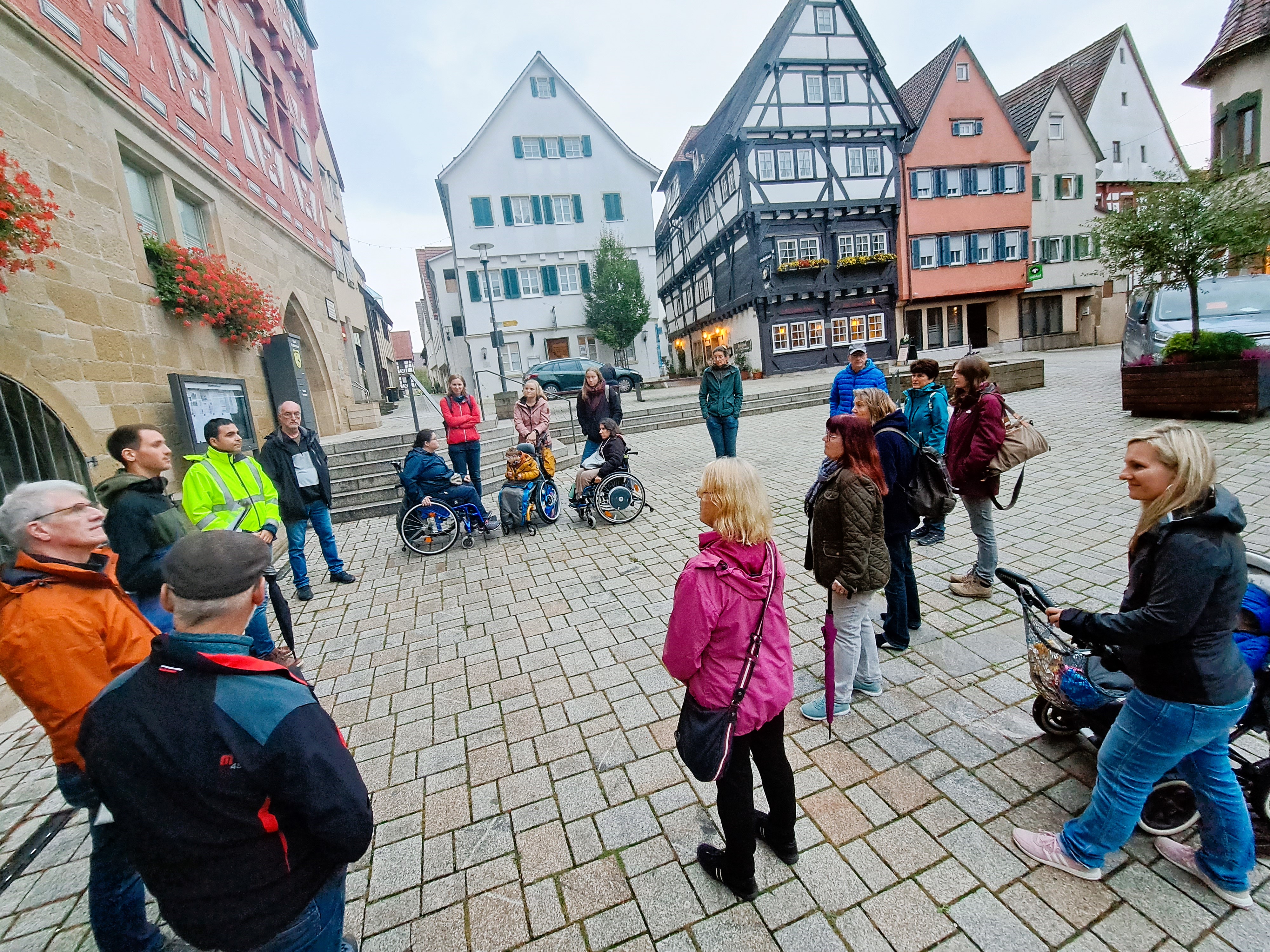 Teilnehmerinnen und Teilnehmer lauschen während der Begehung einem Vortrag.