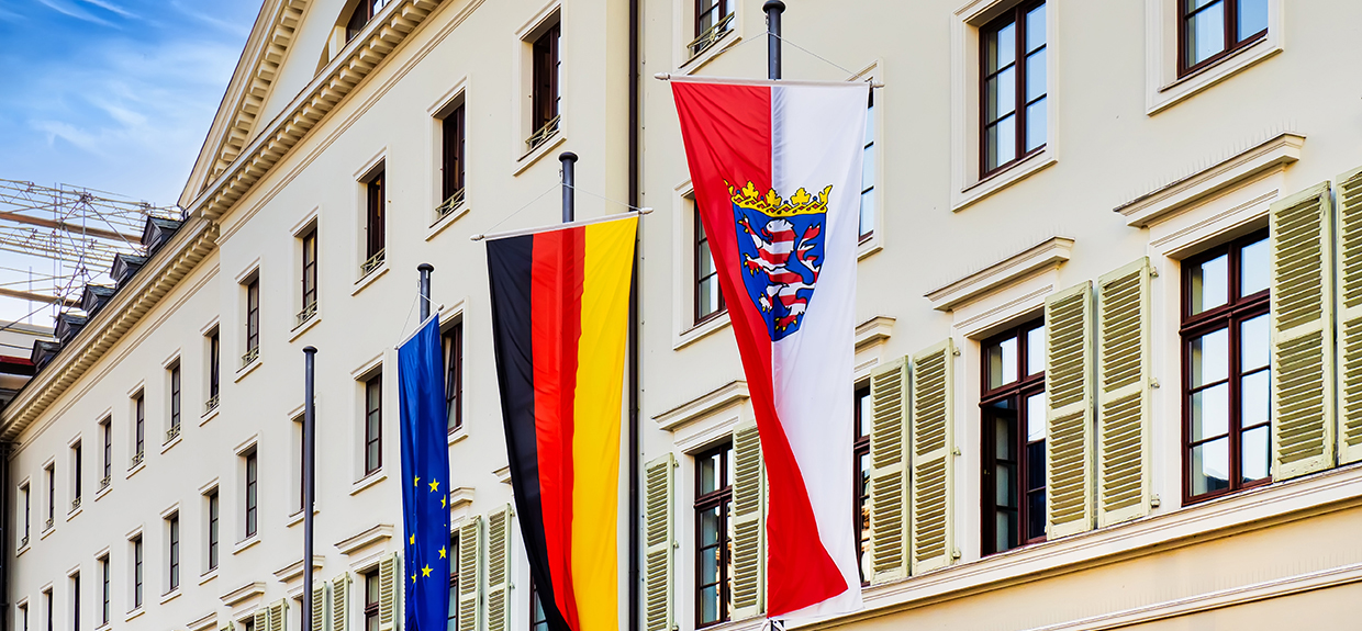 Bild der Fassade des Landtags Hessen mit drei wehenden Flaggen: EU, Deutschland und Hessen